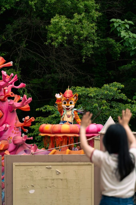 a woman taking a picture of a dragon float