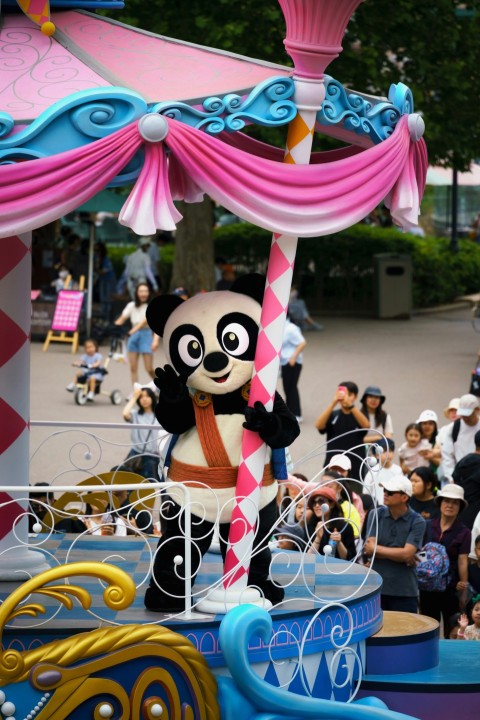 a parade float with a panda riding on top of it