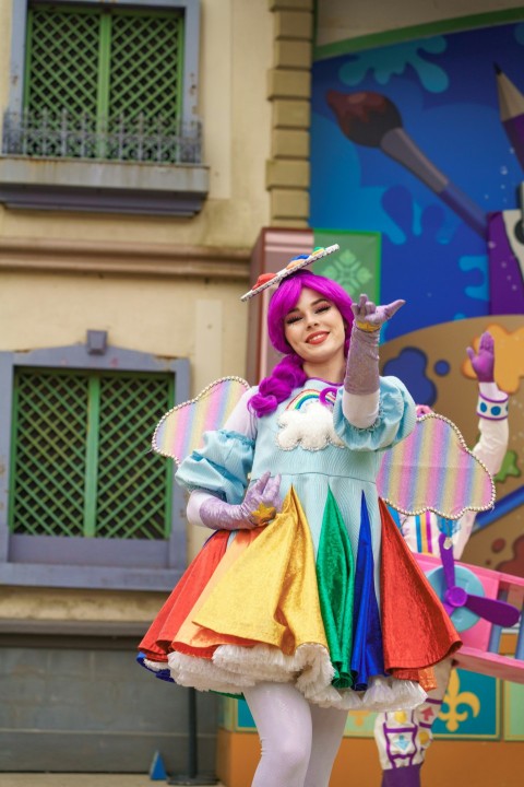 a woman dressed in a rainbow colored costume