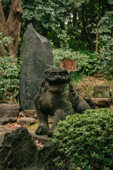 a stone statue of a frog in a garden