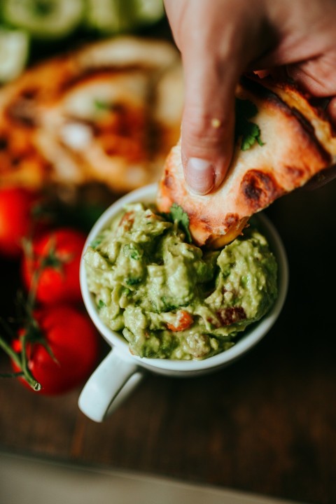 person holding green and brown food