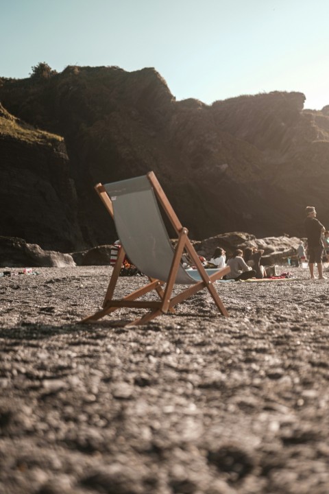 brown wooden folding chair on white sand during daytime