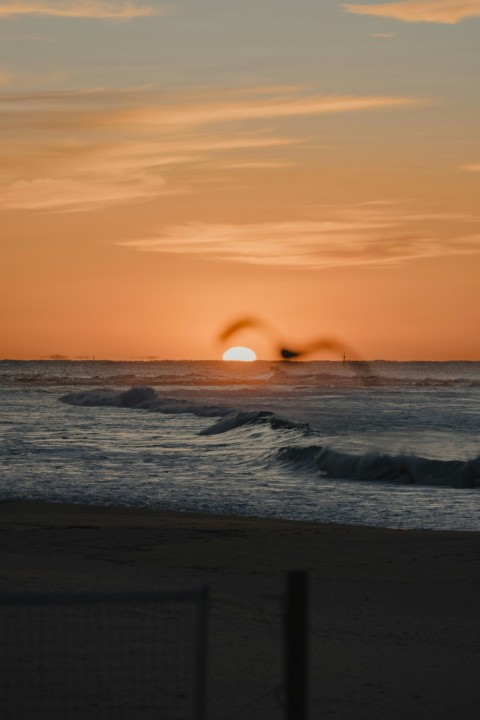 the sun is setting over the ocean with waves