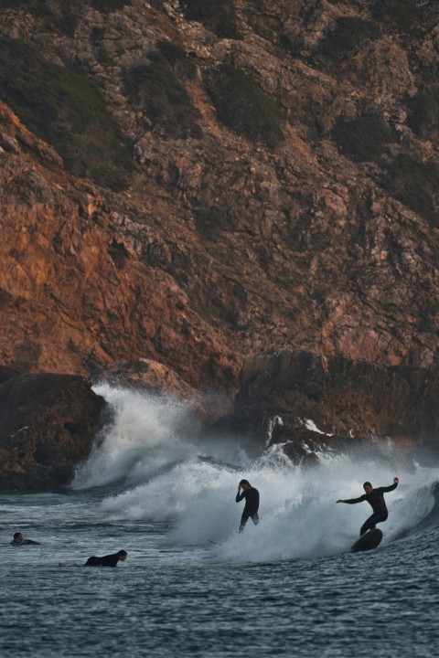 three surfers are riding a wave in the ocean