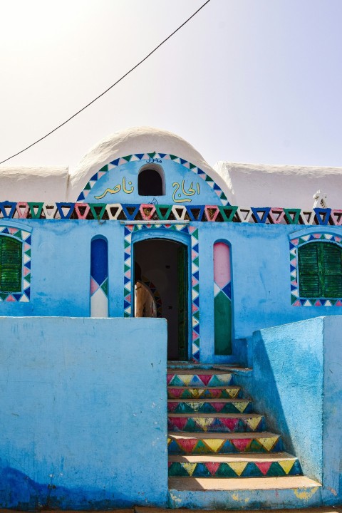 a blue building with colorful steps and windows