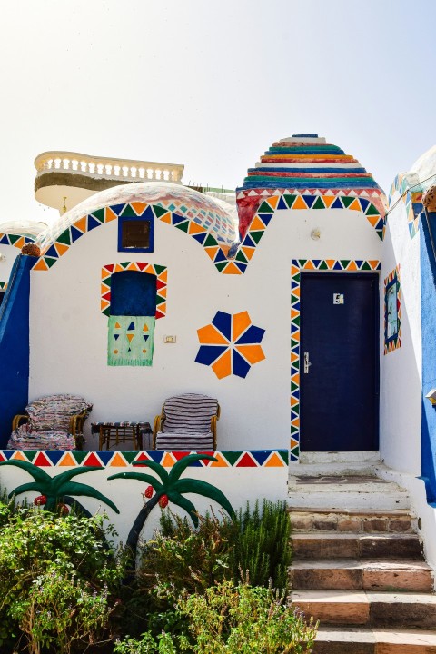 a white building with a blue door and some steps