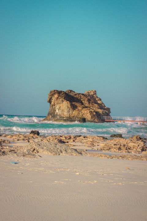 a large rock sitting on top of a sandy beach