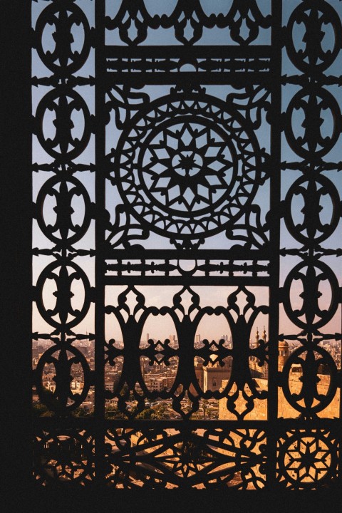 a view of a city through a metal gate