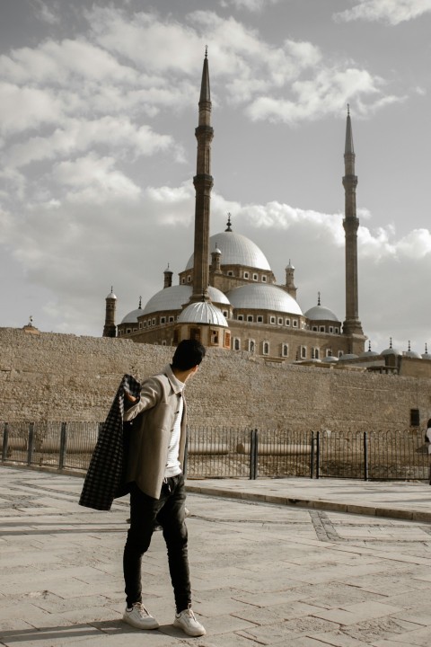 a man standing in front of a large building