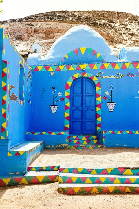 a blue building with a blue door and steps