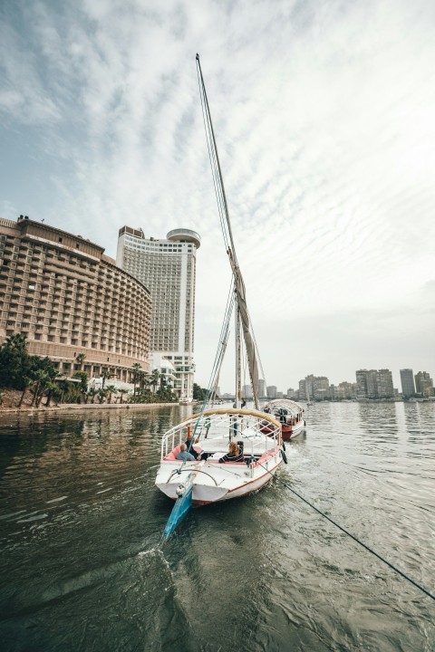 white sailboat at the river during daytime