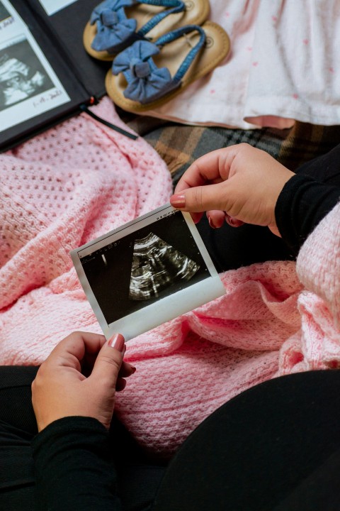 a person is holding a picture of a baby P4_ET