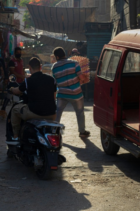 people riding on red car during daytime