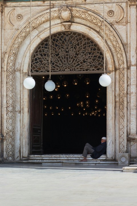 man in black jacket sitting on concrete bench