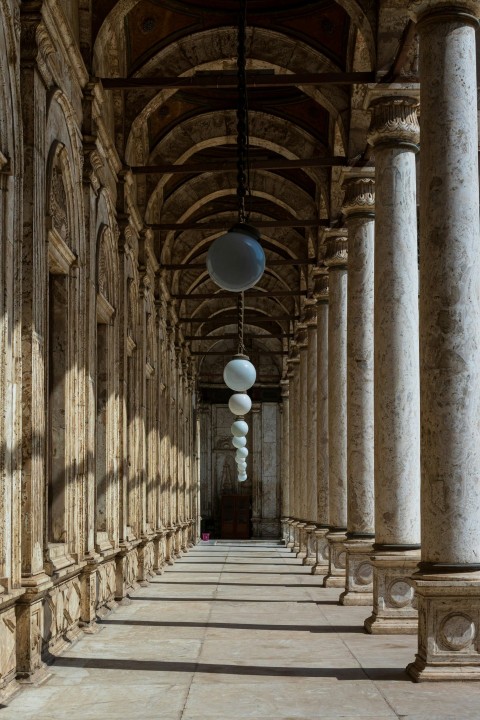 brown brick hallway with white ceiling lamps