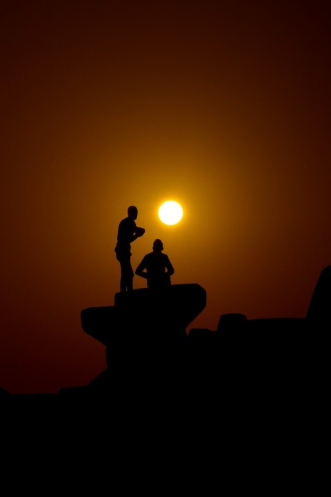 a couple of people standing on top of a hill