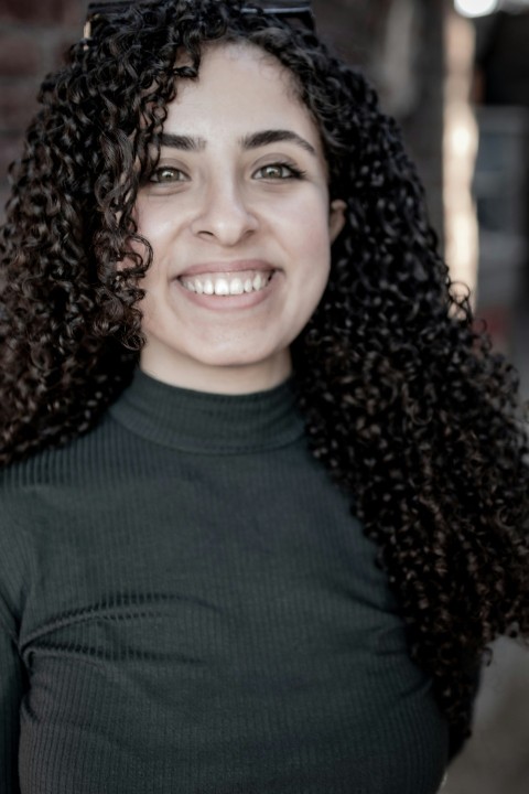 a woman with long curly hair smiling