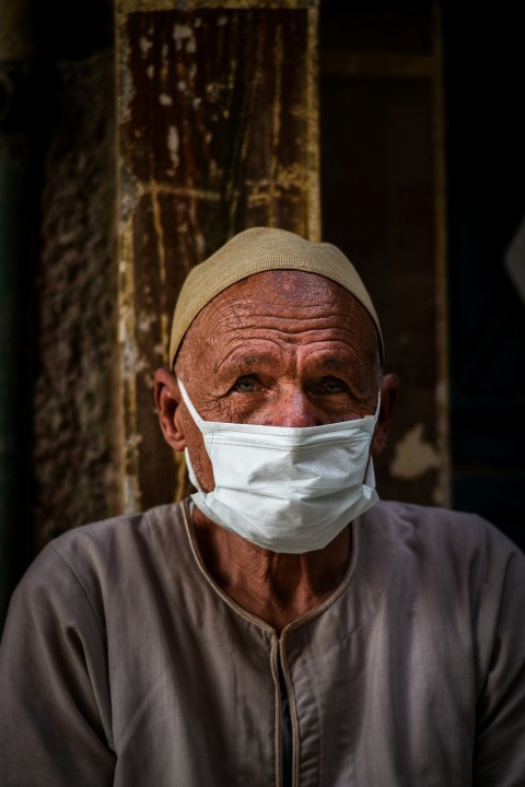 man in white face mask and gray crew neck shirt