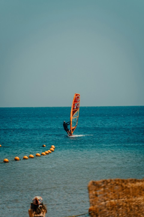 a person on a sailboard in the water