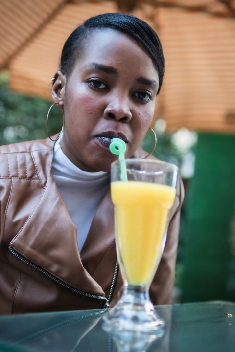 a woman drinking a glass of orange juice