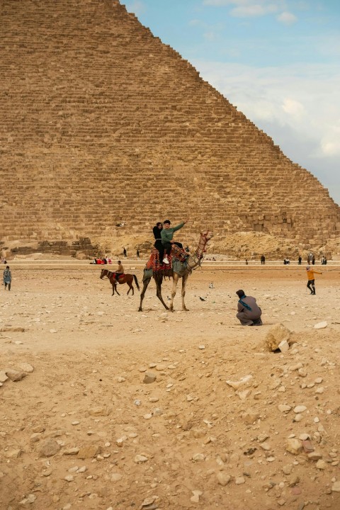 a man on a horse in front of a pyramid