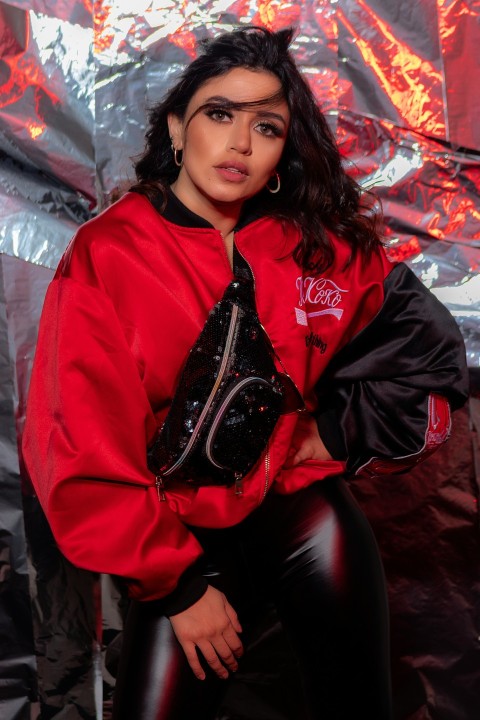 woman in red jacket sitting on black leather couch