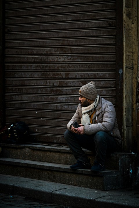 a man sitting on steps looking at his cell phone