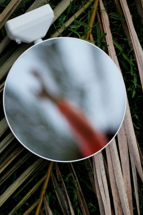 a round mirror sitting on top of a wooden floor