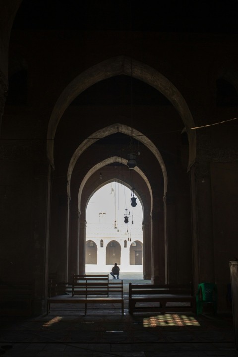 a person sitting on a bench in a church