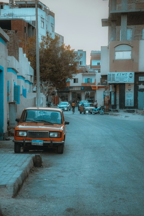 an orange truck parked on the side of a road Cu