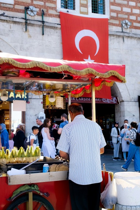 a person stands in front of a fruit stand