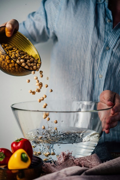 person holding clear glass bowl with corn qykfT