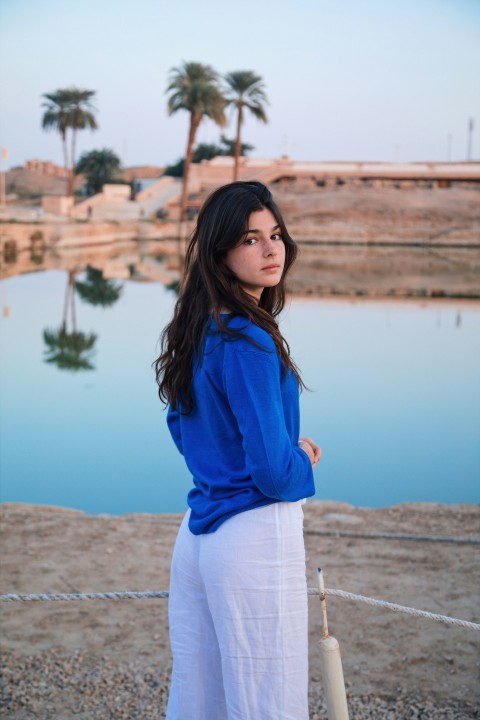 a woman standing in front of a body of water