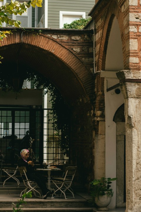 a person sitting at a table outside of a building