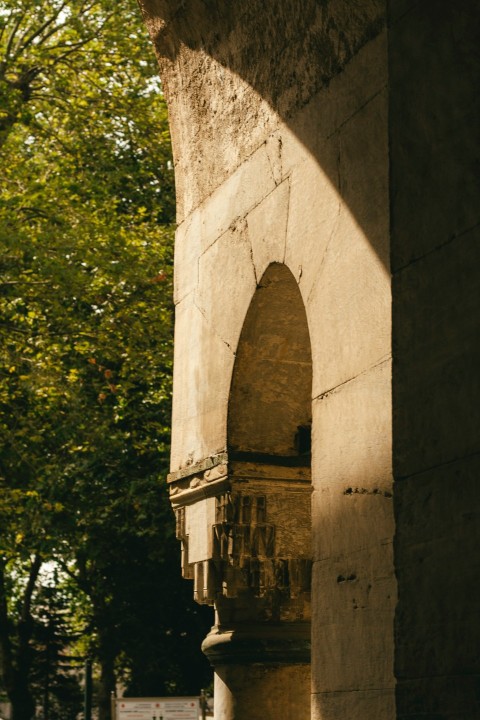 a stone arch with a clock on the side of it