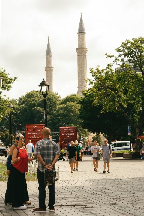 a group of people standing on a sidewalk PoY7t