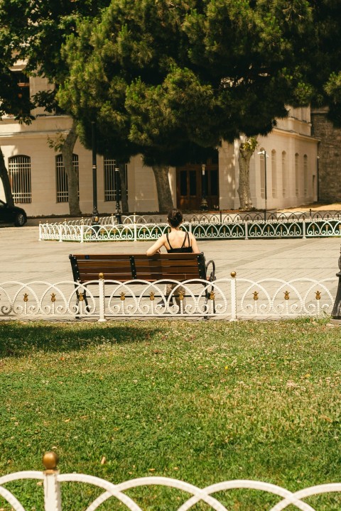 a person sitting on a bench in a park