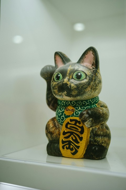 a cat figurine sitting on top of a shelf