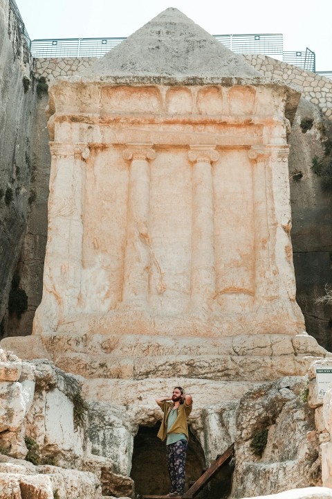 man standing near rock sculpture 1