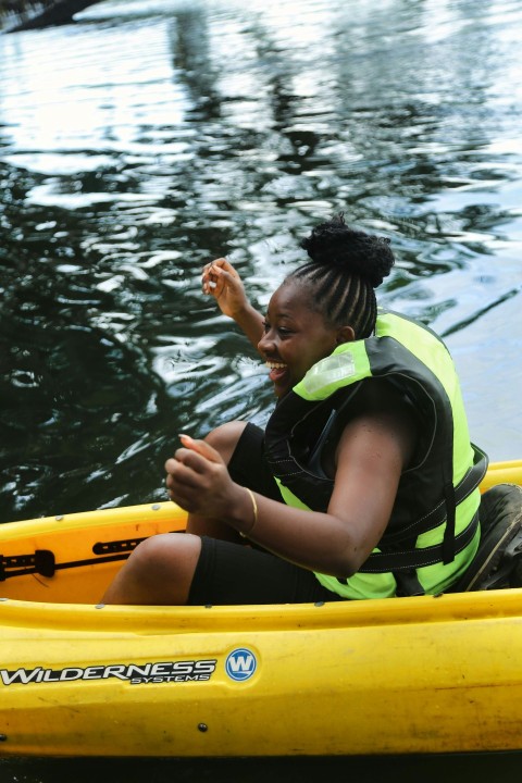 a woman sitting in a yellow kayak in the water