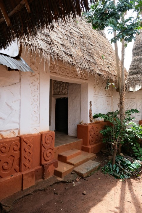 a white house with a thatched roof and steps