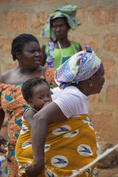 a woman carrying a child on her back