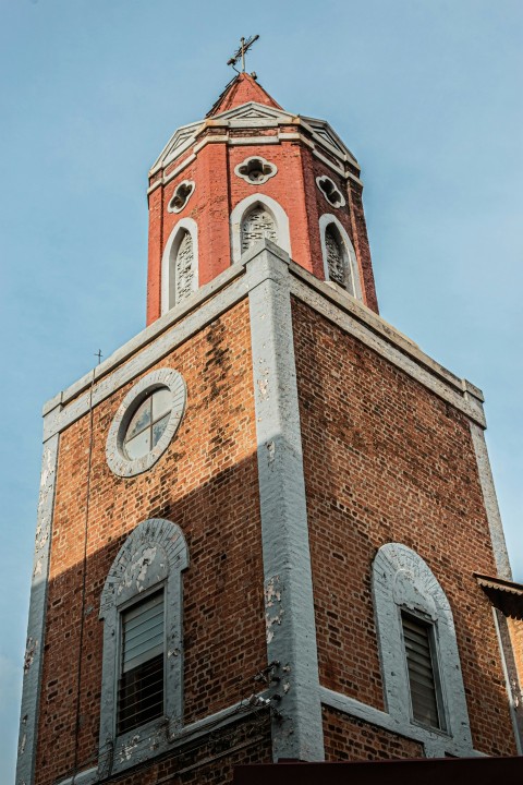 a tall brick building with a clock on its side