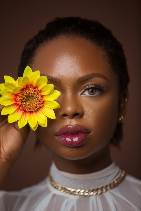 a woman holding a flower up to her face