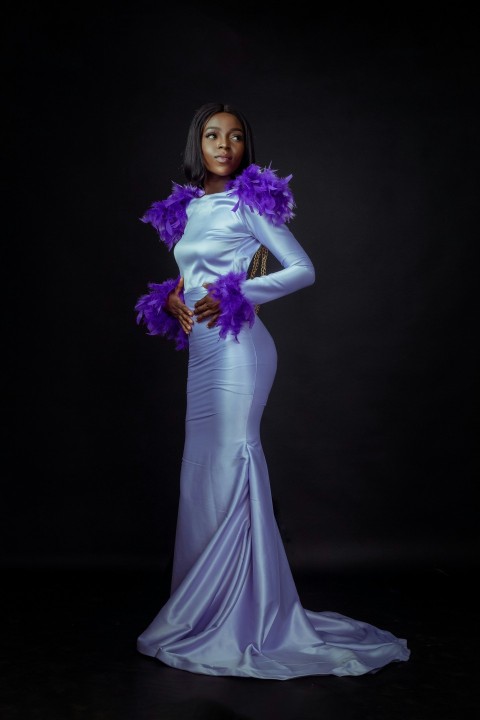 a woman in a white dress with purple feathers