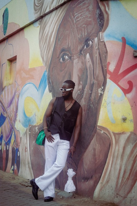 a man standing in front of a wall with graffiti