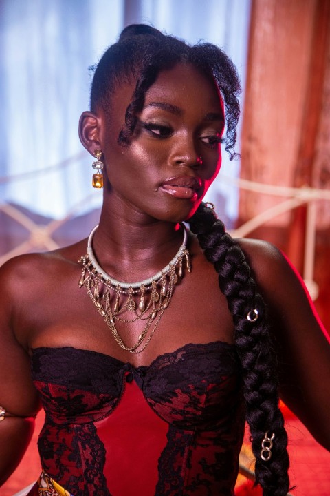 a woman wearing a red dress and gold jewelry