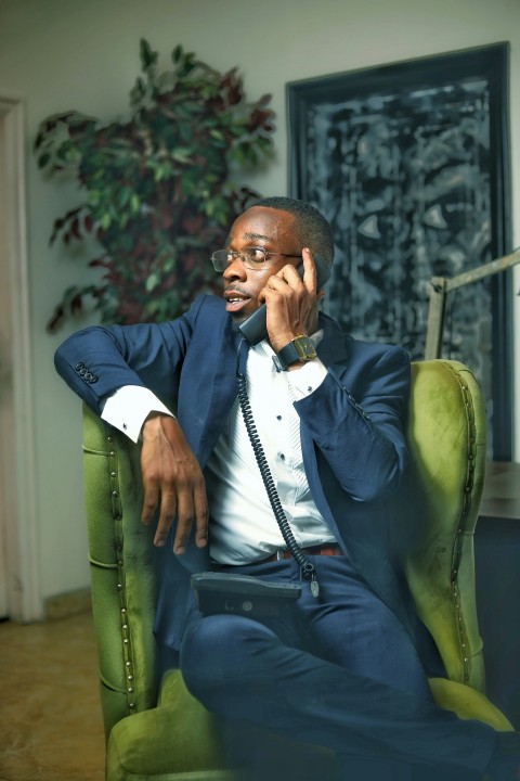 a man sitting in a chair talking on a cell phone