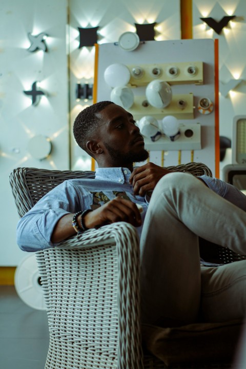 a man is sitting in a wicker chair