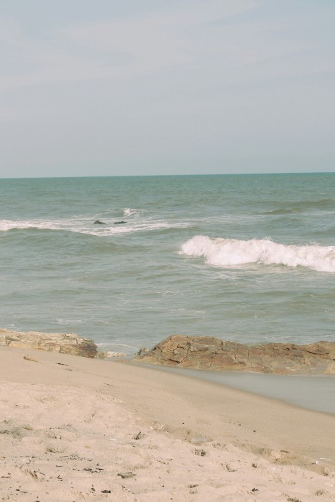 a sandy beach with waves crashing